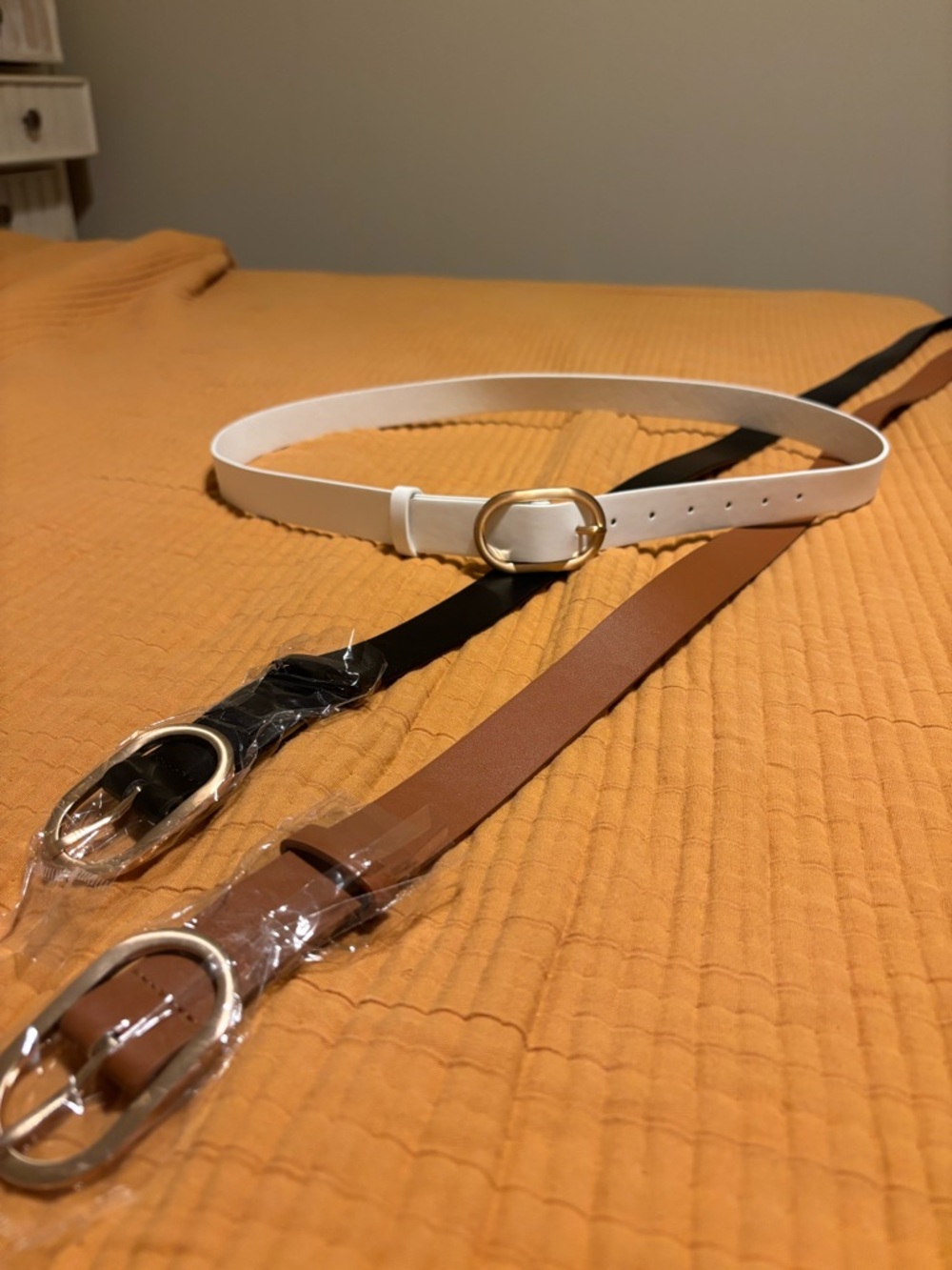 Sleek oval gold buckle. Comes with 3 belts tan, brown and white.
